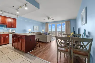 a kitchen and living room with a couch and a table at Bright & Spacious Condo 1BD! Steps from the Beach! by Dolce Vita Getaways PCB in Panama City Beach
