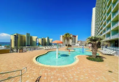 a swimming pool in the middle of a beach at Bright & Spacious Condo 1BD! Steps from the Beach! by Dolce Vita Getaways PCB in Panama City Beach