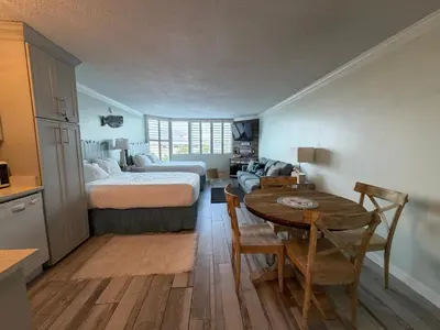 a bedroom with a bed and a table and a couch at Renovated Beach Front Condo - Top of the Gulf 302 in Panama City Beach