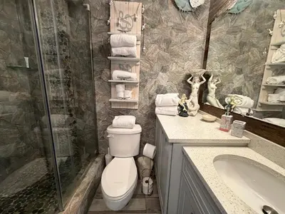 a bathroom with a toilet and a shower and a sink at Renovated Beach Front Condo - Top of the Gulf 302 in Panama City Beach