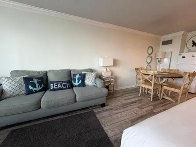 a living room with a couch and a table at Renovated Beach Front Condo - Top of the Gulf 302 in Panama City Beach