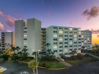 a large building with a parking lot in front of it at Renovated Beach Front Condo - Top of the Gulf 302 in Panama City Beach
