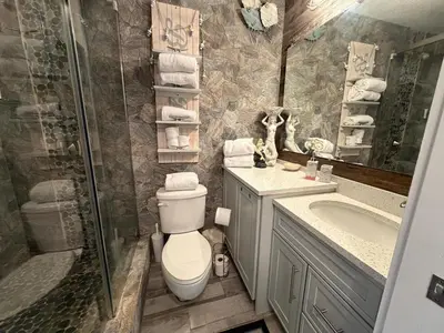 a bathroom with a toilet and a shower and a sink at Renovated Beach Front Condo - Top of the Gulf 302 in Panama City Beach