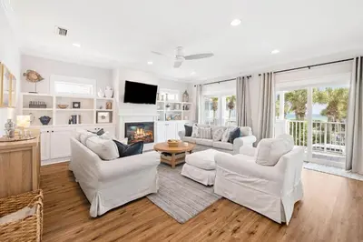 a living room with white furniture and a fireplace at Fore Seasons by 30A Escapes in Seagrove Beach