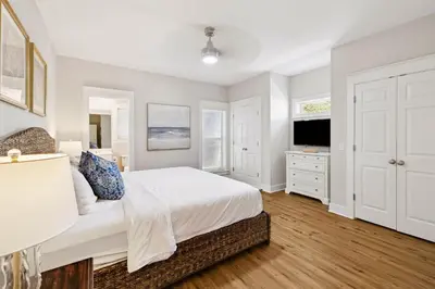 a white bedroom with a bed and a television at Fore Seasons by 30A Escapes in Seagrove Beach