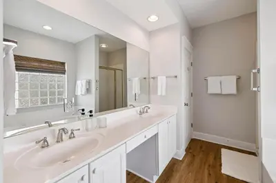 a white bathroom with two sinks and a mirror at Fore Seasons by 30A Escapes in Seagrove Beach