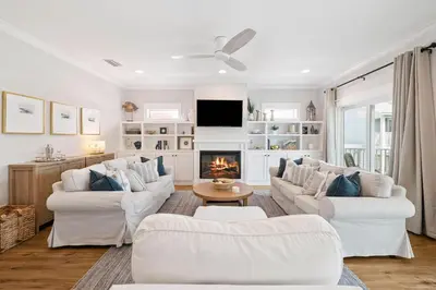 a living room with white furniture and a fireplace at Fore Seasons by 30A Escapes in Seagrove Beach