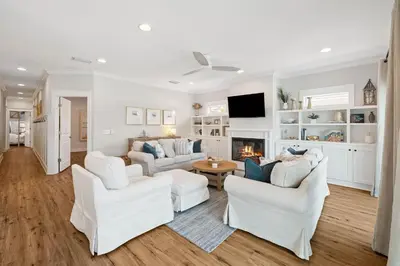 a living room with white furniture and a fireplace at Fore Seasons by 30A Escapes in Seagrove Beach