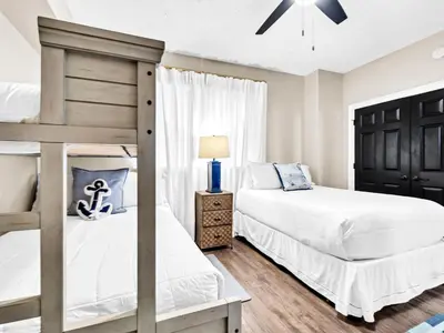 a bedroom with two bunk beds and a lamp at Hidden Dunes 704 in Panama City Beach