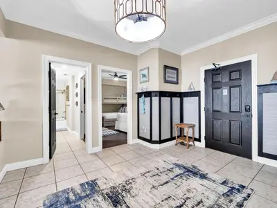 a living room with a black door and a rug at Hidden Dunes 704 in Panama City Beach