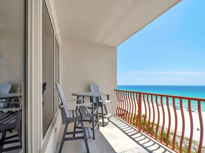 a balcony with chairs and a table and the ocean at Hidden Dunes 704 in Panama City Beach