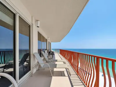 a balcony with chairs and the ocean in the background at Hidden Dunes 1705 in Panama City Beach