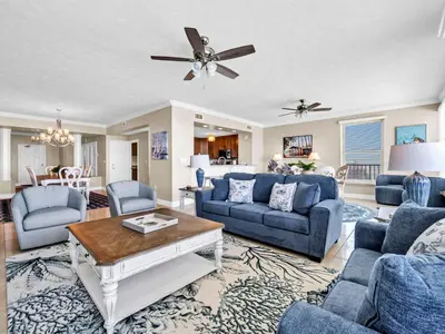 a living room with blue couches and a table at Hidden Dunes 1705 in Panama City Beach