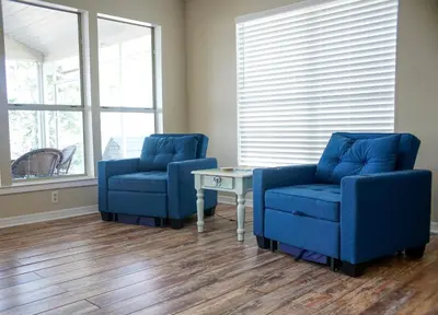 two blue chairs and a table in a room at Lagoon Landing Waterfront Home in Panama City Beach