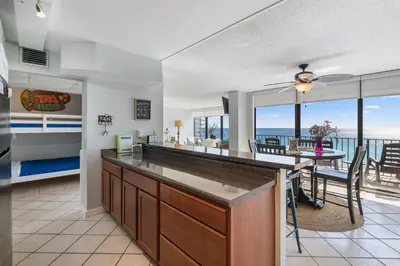 a kitchen and dining room with a view of the ocean at 1007 Edgewater T1 Beach Resort in Panama City Beach