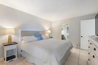 a bedroom with a large white bed with blue pillows at 1007 Edgewater T1 Beach Resort in Panama City Beach