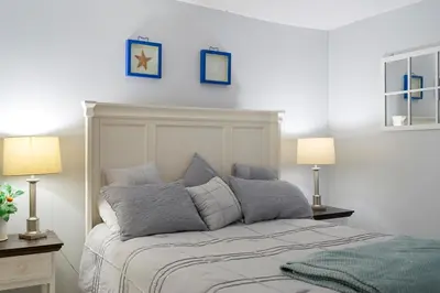 a bedroom with a bed with two lamps and two pictures on the wall at 1007 Edgewater T1 Beach Resort in Panama City Beach