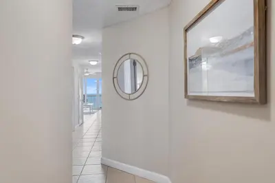 a hallway with a mirror and a white wall at 1202 Seychelles in Panama City Beach