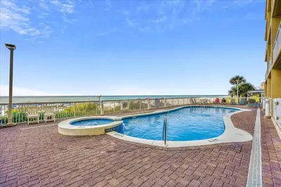 a swimming pool with the ocean in the background at 1202 Seychelles in Panama City Beach