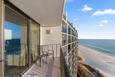 a balcony with a chair and the ocean at 1107 Edgewater T3 Beach Resort in Panama City Beach