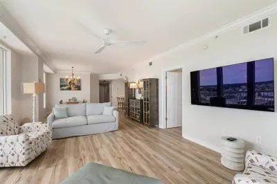 a living room with a couch and a tv on a wall at 1209 Seychelles in Panama City Beach