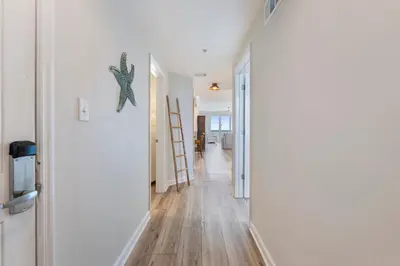 a hallway with white walls and a starfish on the wall at 1209 Seychelles in Panama City Beach