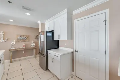 a kitchen with white cabinets and a refrigerator at 305 Sterling Beach in Panama City Beach