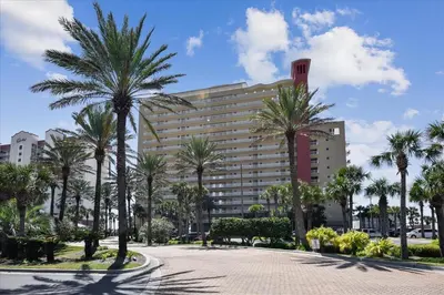 a large building with palm trees in front of it at 305 Sterling Beach in Panama City Beach