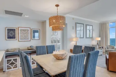 a dining room and living room with a table and chairs at 607 Sterling Beach in Panama City Beach