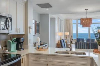 a kitchen with a sink and a view of the ocean at 607 Sterling Beach in Panama City Beach