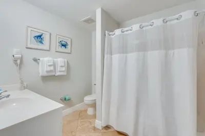 a white bathroom with a shower curtain and a toilet at 607 Sterling Beach in Panama City Beach