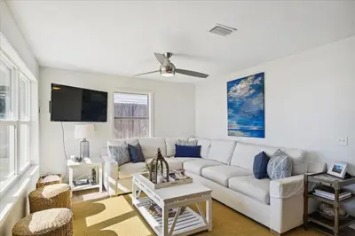 a living room with a white couch and a tv at The Southern Yankee in Panama City Beach
