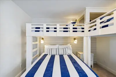 a bedroom with a bunk bed with blue and white stripes at The Southern Yankee in Panama City Beach