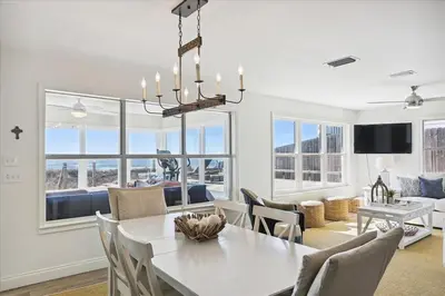 a dining room and living room with a white table and chairs at The Southern Yankee in Panama City Beach