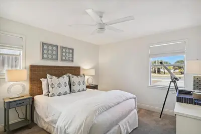 a white bedroom with a bed and a window at The Southern Yankee in Panama City Beach