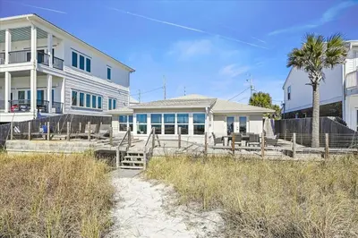a large white house with a palm tree in front of it at The Southern Yankee in Panama City Beach