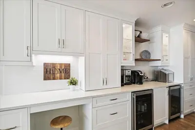 a white kitchen with white cabinets and a counter at The Southern Yankee in Panama City Beach