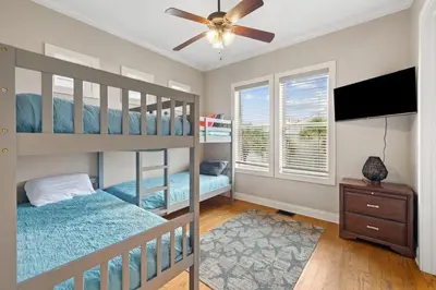 a bedroom with two bunk beds and a ceiling fan at Sunset Serenity in Panama City Beach