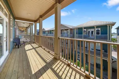 a large deck with a chair on a house at Sunset Serenity in Panama City Beach
