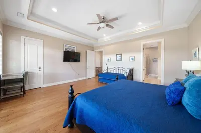 a bedroom with a blue bed and a ceiling fan at Sunset Serenity in Panama City Beach