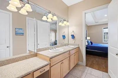 a bathroom with two sinks and a large mirror at Sunset Serenity in Panama City Beach