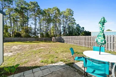 a backyard with a table and chairs and a fence at Hilltop Manor in Panama City Beach