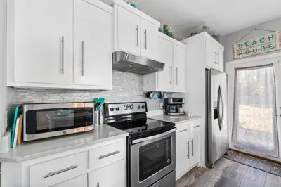 a kitchen with white cabinets and a stove top oven at Hilltop Manor in Panama City Beach