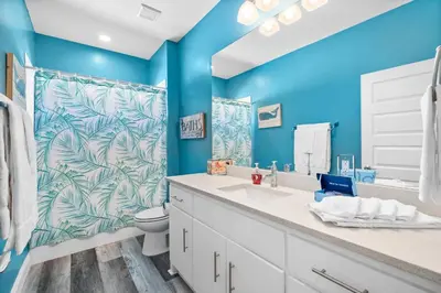 a blue bathroom with a toilet and a sink at Hilltop Manor in Panama City Beach