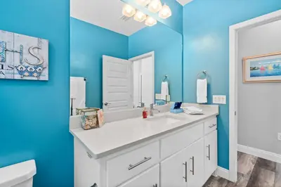 a bathroom with a white sink and a mirror at Hilltop Manor in Panama City Beach