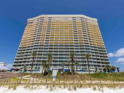a large building with palm trees in front of it at Boardwalk #1602 in Panama City Beach