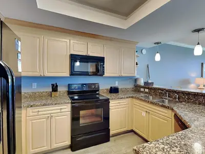 a kitchen with a black stove and a microwave at Boardwalk #1602 in Panama City Beach