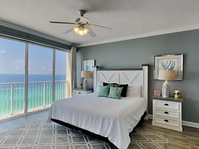 a bedroom with a bed with a view of the ocean at Boardwalk #1602 in Panama City Beach