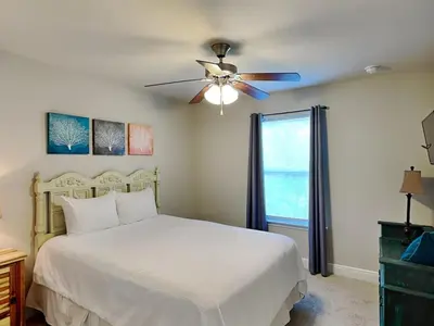 a bedroom with a white bed and a ceiling fan at Southern Charm in Inlet Beach
