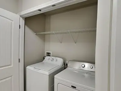 a small white laundry room with a washer and dryer at Southern Charm in Inlet Beach